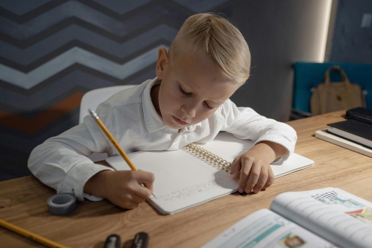 A blonde boy doing some homework revision.